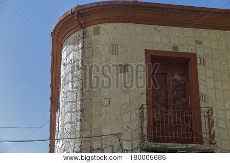 foreground of a balcony on a facade decorated with crochet work