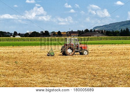Tractor With Plough Doing Some Agricultural Seasonal Work At Field