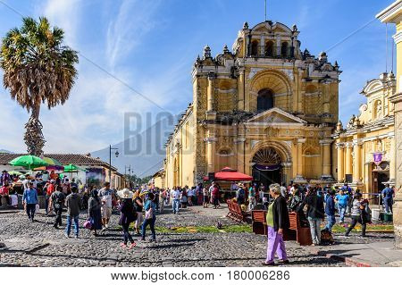 Antigua, Guatemala - April 2 2017: Pine needle procession carpets outside Hermano Pedro church during Lent against backdrop of Agua volcano in colonial town with most famous Holy Week celebrations in Latin America.