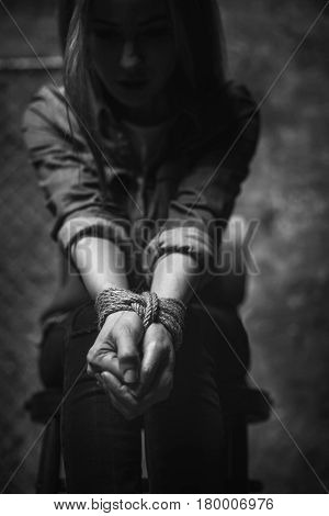 No one gonna save me. Weak desperate trapped girl sitting on a chair being all tied up and feeling despair