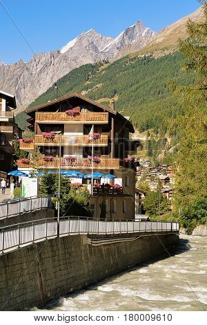 Traditional Swiss Chalets And Gornera River In Resort Town Zermatt