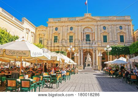 People Resting In Open Air Cafes At Republic Square Valletta