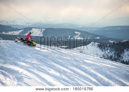 Rider on the snowmobile in the mountains ski resort in Amut Russia.
