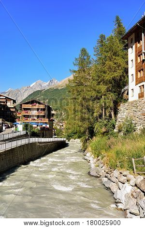 Traditional Swiss Chalets And Gornera River At Resort Town Zermatt