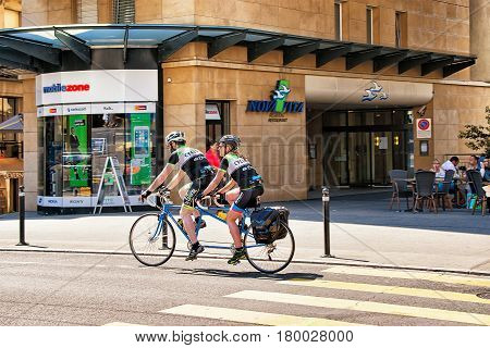 People Riding Tandem Bicycle On Street In Montreux