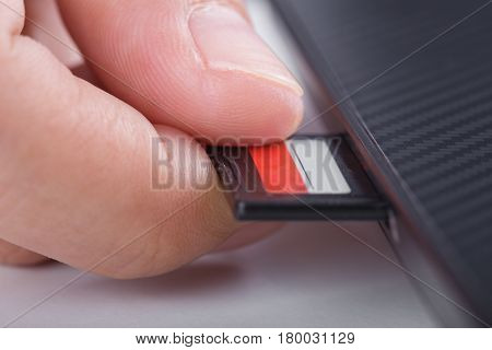 Hand Inserting Sd Card Into Laptop