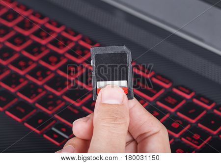 Hand Holding Sd Card With Laptop