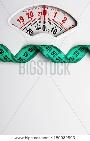 Green Measuring Tape On Weight Scale. Dieting