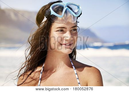 Young cute Diver girl on beach looking away