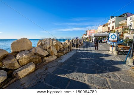 Piran Slovenia - January 7 2017: The historic lighthouse on the picturesque promenade with old houses. The old city of Piran - Mediterranean city in Slovenia Adriatic Sea.