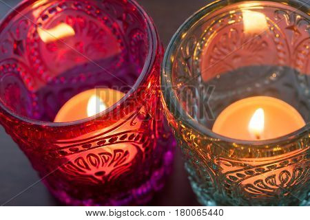 pink candle and light blue candle on a table .