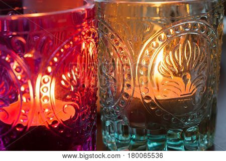pink candle and light bule candle on a table .
