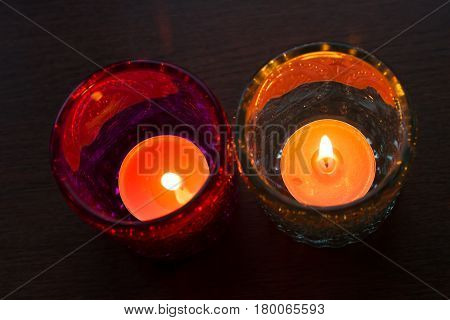 pink candle and light bule candle on a table .