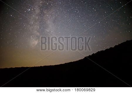 A Clear Night Sky With A Hill And Trees In The Foreground