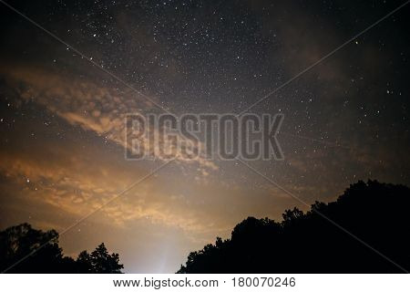 A Clear Night Sky With A Hill And Trees In The Foreground