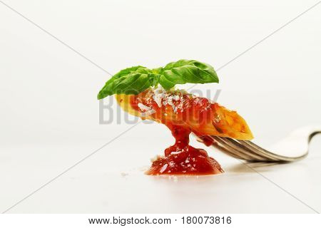 Tasty colorful appetizing cooked spaghetti italian pasta with tomato sauce bolognese and fresh basil on fork. Creative serving Closeup.