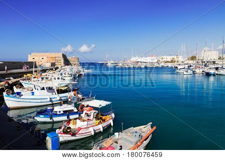 Heraklion old venetian harbour with colorful small fishing boats, yachts and ships, Heraclion Crete, Greece