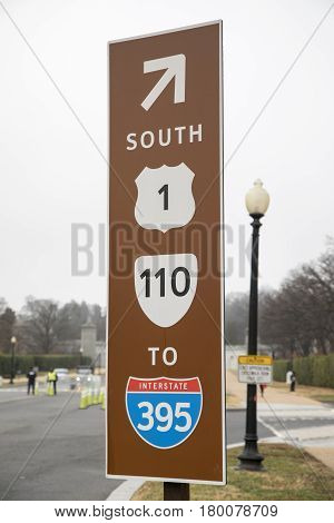 A brown road sign for route 1, 110 and Interstate 395 in Virginia