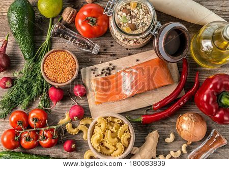 Variety of fresh fruits and veggies on the table, oats and spices, salmon fillet, topshot