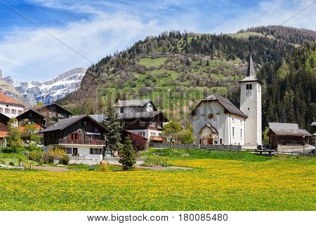 Beautiful Alpine landscape  with church  and typical Swiss houses  at spring sunny day , Inden village , canton of Valais , Switzerland.