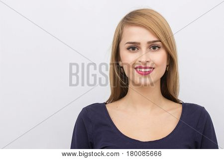 Fashion portrait of a girl posing in bright, spacious studio with a gray background in a stylish comfortable and simple clothes. young girl with clean skin and perfect face