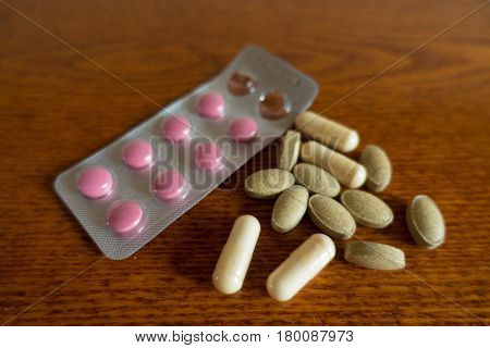 Blister with tablets and capsules on wood