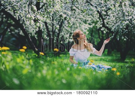 beautiful young woman in floral maxi skirt walking in spring