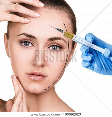 Young woman getting cosmetics injection over white background.