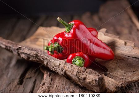 Red chilly pepper on wooden black background. Red hot chili peppers. Domestic cultivation extra hot chilli burn.