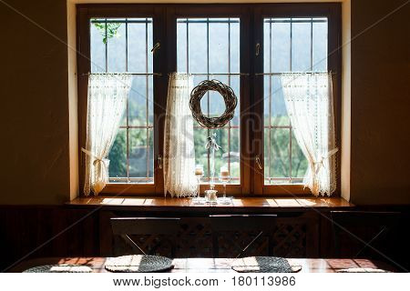 Window decorate by beautifyl wreath inside a cottage.