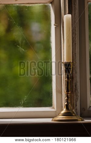 Old vintage objects wood concept. Old vintage window and vertical candle in candlestick