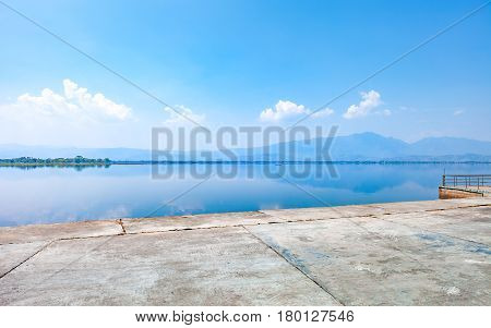 calmness lake in the morning with mountain and reflection in the water Kwan Phayao or Phayao Lake Northern of Thailand