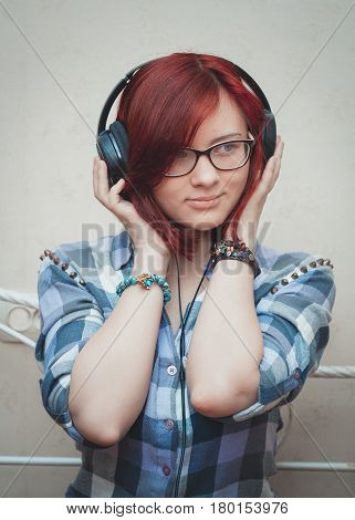 teen girl with red hair in headphones