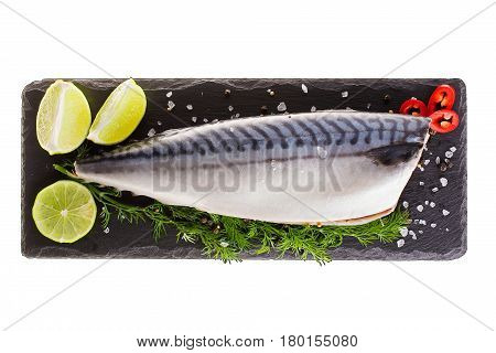 Raw mackerel with lemon and herbs on black slate cutboard isolated on white background. top view