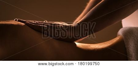 Massage closeup view with hands of professional masseur. Charming lighting