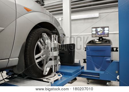 Grid sensor sets mechanic on auto. Car stand with sensors wheels for alignment camber check in workshop of Service station