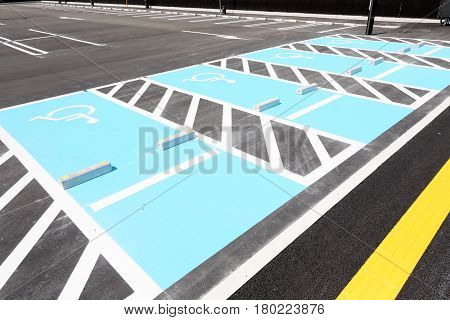 Road marking for handicapped parking stall in a parking lot