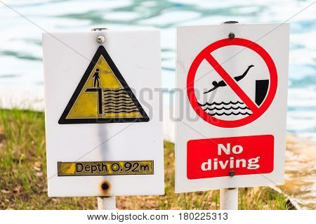 Closeup of no diving and depth signs in swimming pool