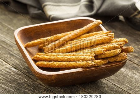 Salty pretzel sticks in wooden bowl.