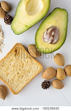Sliced avocado oats toast and whole almonds view from above white background breakfast