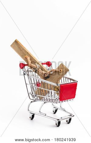 Crucifix in shopping cart. Conceptual representation of commodification of religion loss of faith blasphemy.