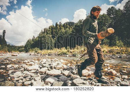 Man traveler lumberman holding wood Travel survival Lifestyle concept adventure summer vacations outdoor wild forest and river on background