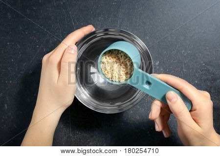 Putting brown rice into bowl with water