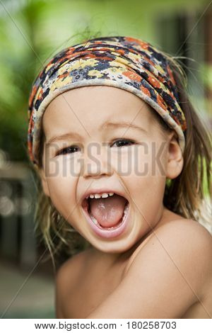 Portrait of a crying baby with a kerchief on her head asian-mestizo close-up