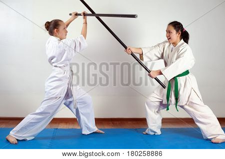 Two girls demonstrate martial arts working together. Fighting position active lifestyle practicing fighting techniques