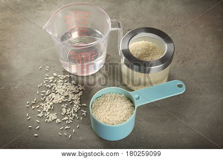 Kitchen ware with rice and water on table