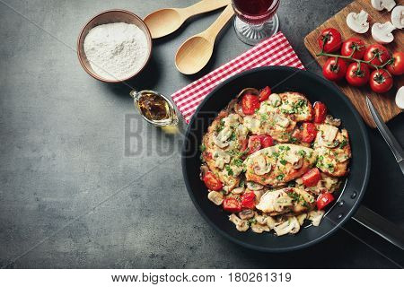 Frying pan with delicious chicken marsala on table