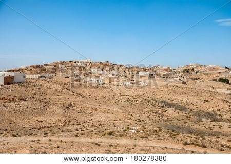 Traditional Arabian city on sand dunes in the desert