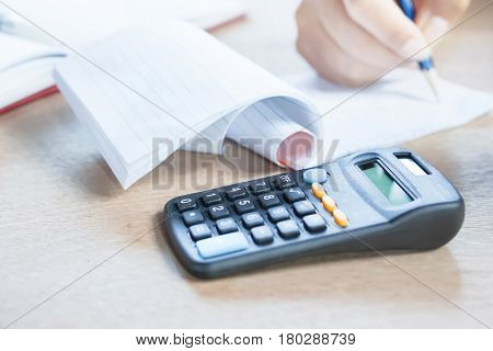 business owner doing their monthly accounting with the calculator in the foreground