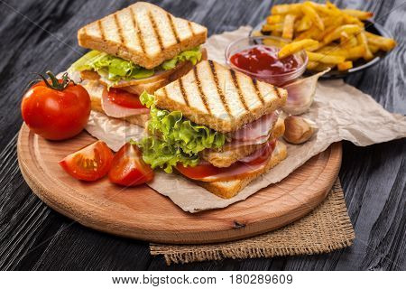 Club Sandwich With Tomato, Lettuce, Bacon, Ham And French Fries